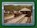 1957: 'Count Louis' with ex-Hardwick twin-bogie wooden-bodied carriages & the half+half carriage at the rear waits to leave the new Fairbourne terminus, postacrd - Bill Hyde collection
