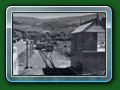 1949: The original Fairbourne terminus, from outside the 'top gate' showing the ex Hardwick Manor mock Signal Box that sold ice creams in its original position. Lot of detail in this picture - Basset-Lowke 4-wheel carriages, one of the Basset-Lowke glass screen/glass end carriages & at least one wooden-bodied twin-bogie carriage, from book 'Short History of Fairbourne Railway' - Bill Hyde collection